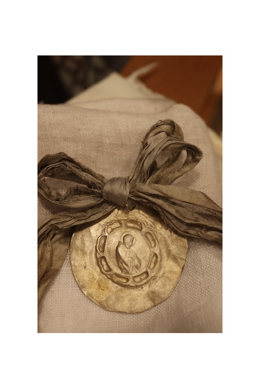 Medalla rústica de San Francisco Javier para carrito de bebé en latón. Hecha artesanalmente por Sandra Bellew.