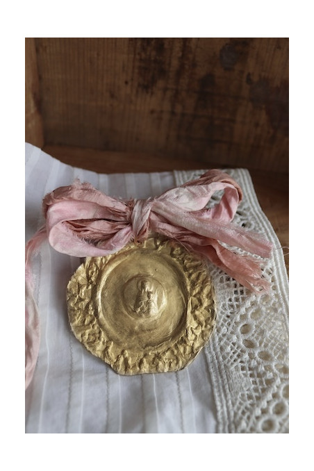 Medalla de cuna rústica de la Virgen de la Mercè en latón. Hecha artesanalmente en España por Sandra Bellew.