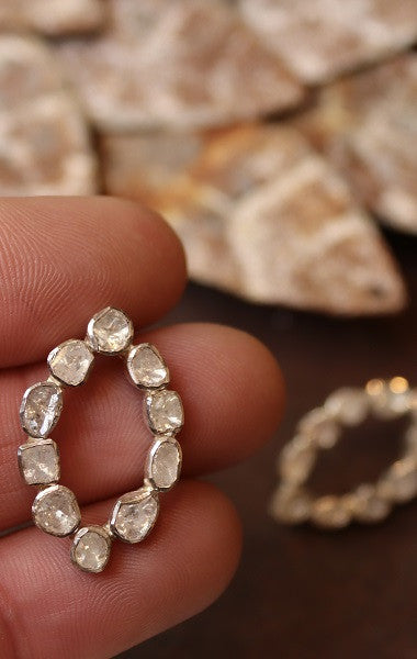 Pendiente con forma de óvalo apuntado de diamantes y plata.