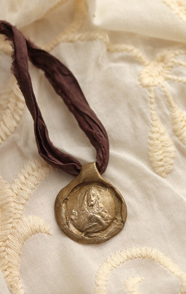 Medalla rústica del Sagrado Corazón en latón. Hecha artesanalmente por Sandra Bellew.