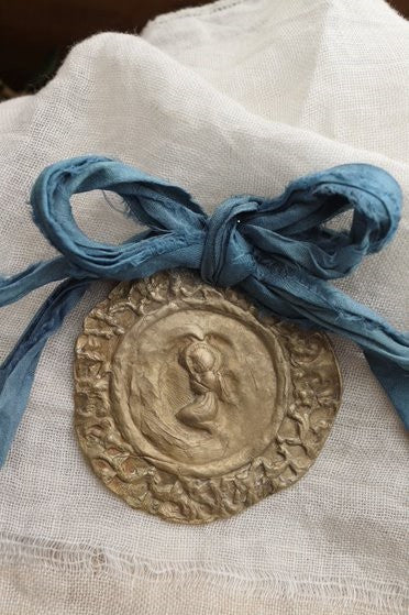 Medalla rústica del Angelito de la Guarda  para cuna en latón. Hecha artesanalmente por Sandra Bellew.