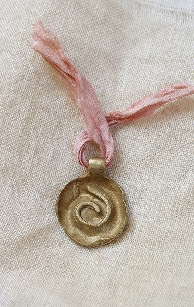 Colgante rústico de espiral celta en latón. Hecho artesanalmente en España por Sandra Bellew.
