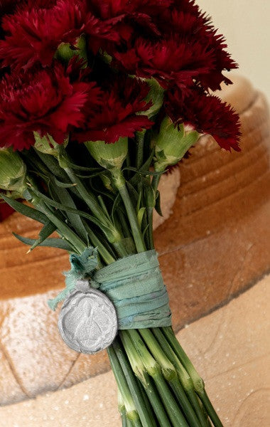 Medalla rústica de San Fermín para ramo en plata. Hecha artesanalmente por Sandra Bellew.