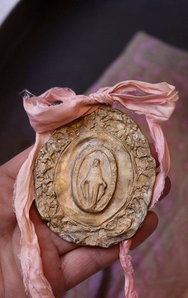Medalla rústica de la Virgen Milagrosa en latón para cuna. Hecha artesanalmente en España por Sandra Bellew.