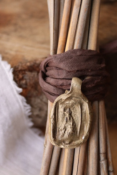 Medalla rústica de la Virgen Blanca para ramo de novia en latón. Hecha artesanalmente en España por Sandra Bellew.