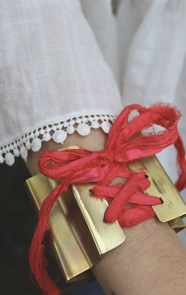Brazalete en forma de abanico en latón con cinta de seda. Hecho artesanalmente por Sandra Bellew.