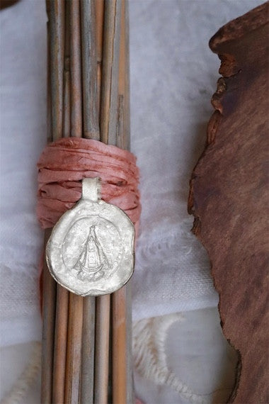 Medalla rústica de la Virgen del Juncal para ramo de novia en plata. Hecha artesanalmente en España por Sandra Bellew.