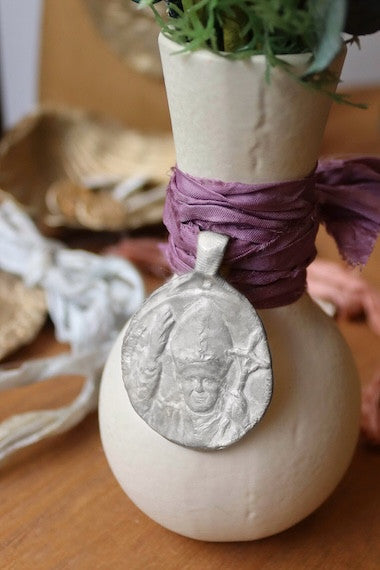 Medalla rústica de San Juan Pablo II para ramo de novia en ramo. Hecha artesanalmente en España por Sandra Bellew.