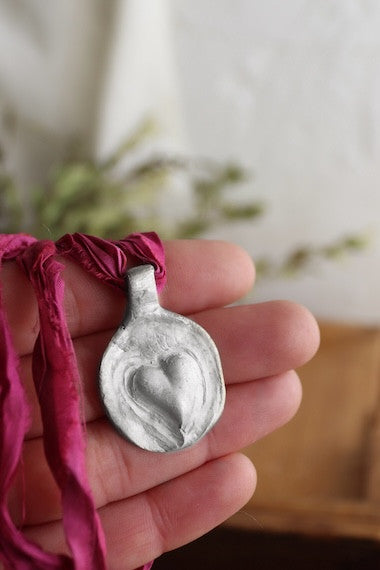 Colgante rústico de un corazón en plata. Hecho artesanalmente en España por Sandra Bellew.