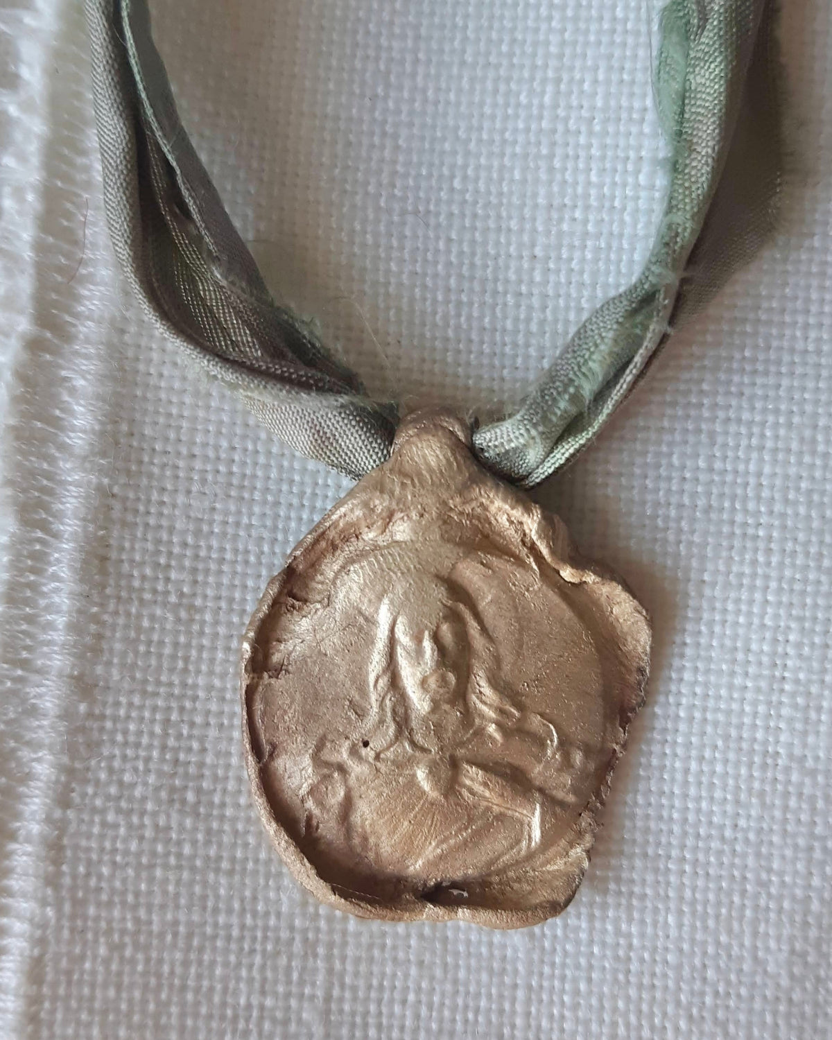 Medalla rústica del Cristo de la Misericordia en latón. Hecha artesanalmente en España por Sandra Bellew.