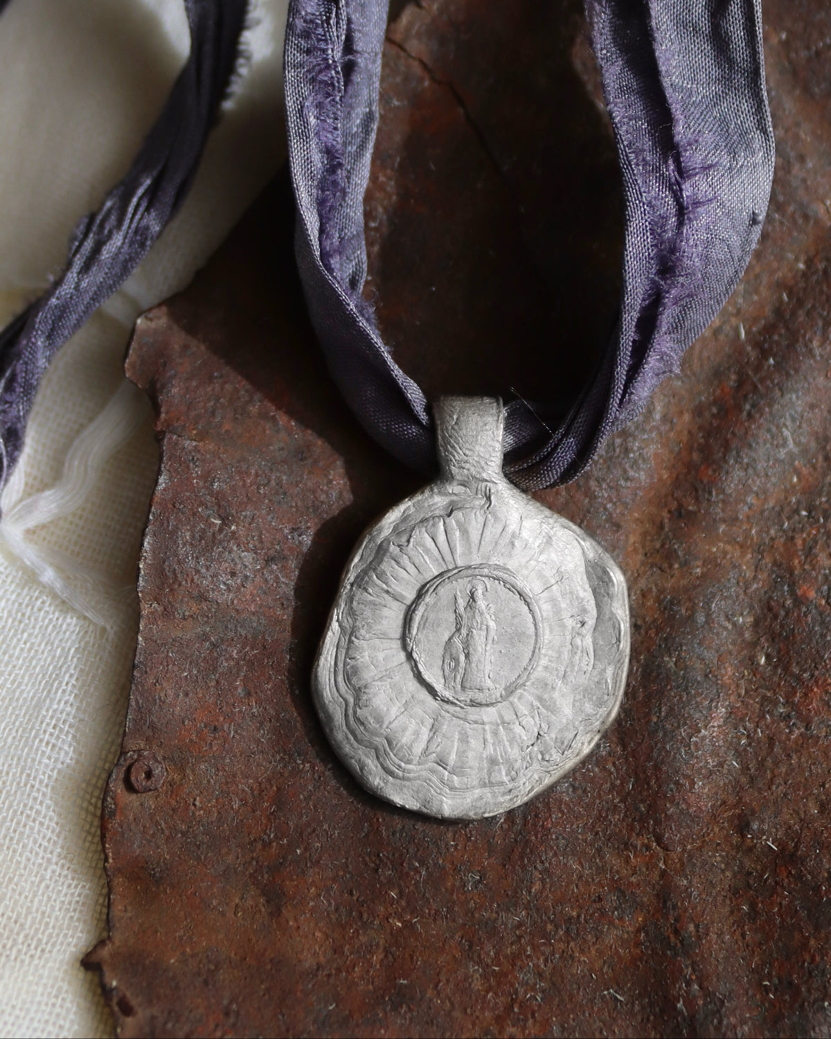 Medalla rústica de Santa Cristina en plata. Hecha artesanalmente en España por Sandra Bellew.