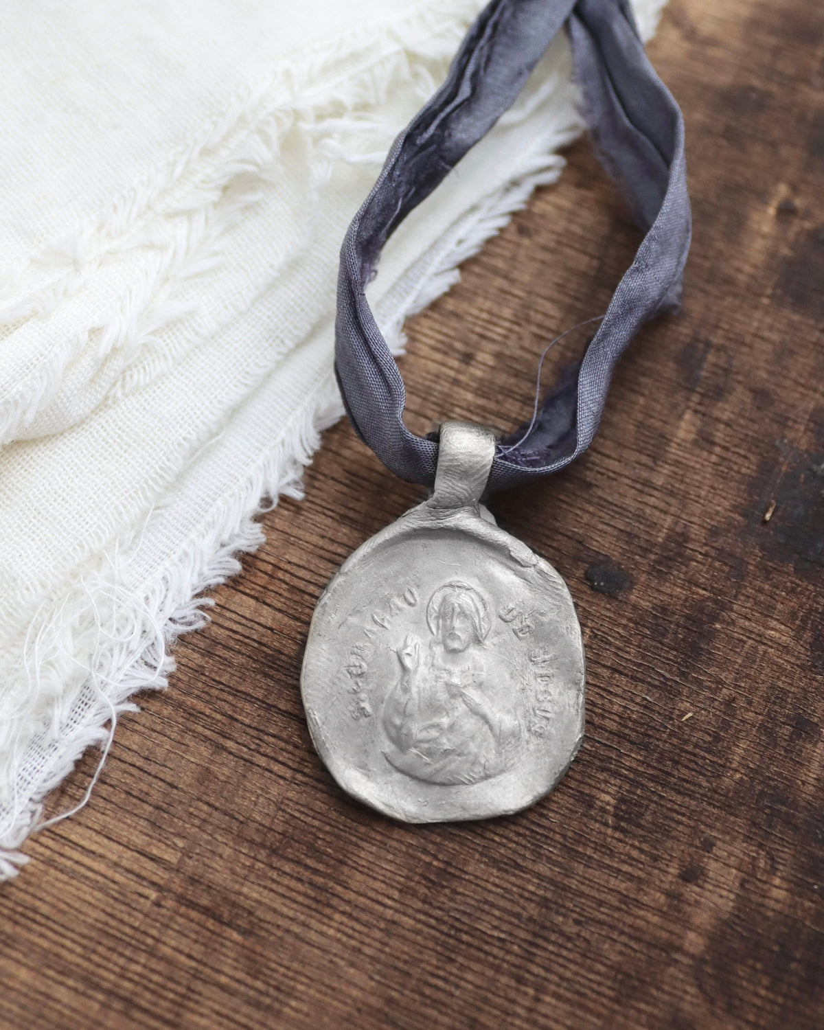 Medalla rústica del Cristo de la Misericordia en plata. Hecha artesanalmente en España por Sandra Bellew.