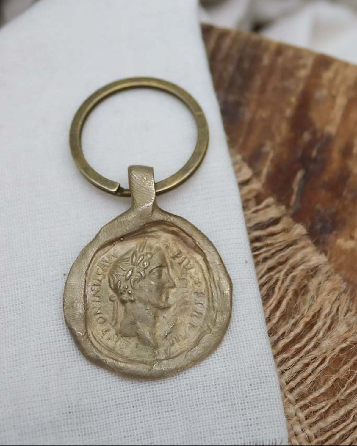 Llavero rústico con imagen de moneda romana en latón. Hecho artesanalmente en España por Sandra Bellew.