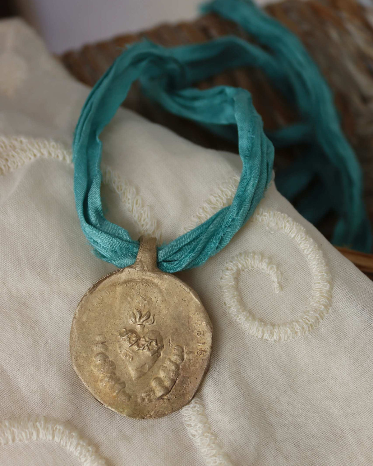 Medalla rústica del Sagrado Corazón en latón. Hecha artesanalmente por Sandra Bellew.