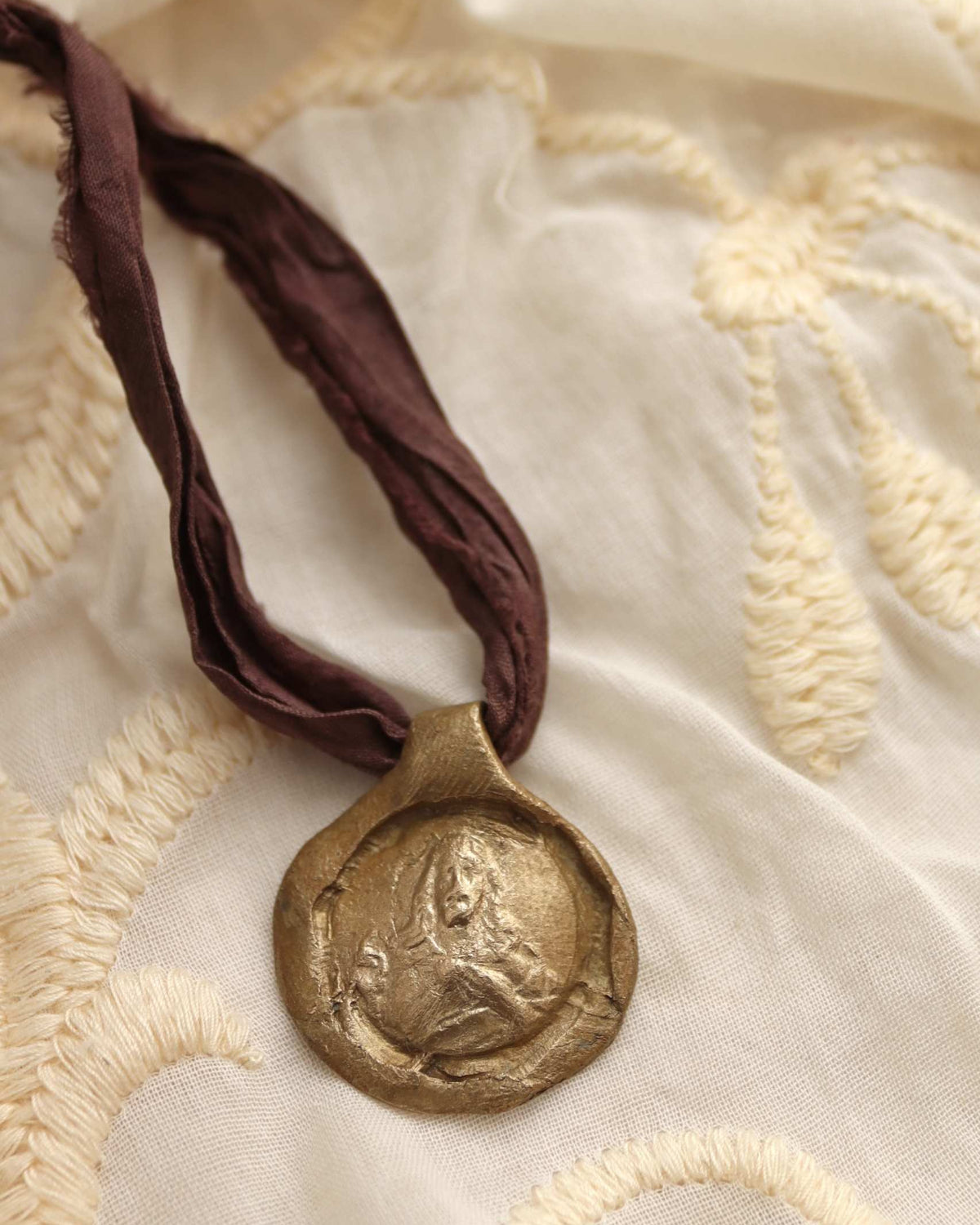 Medalla rústica del Sagrado Corazón en latón. Hecha artesanalmente por Sandra Bellew.