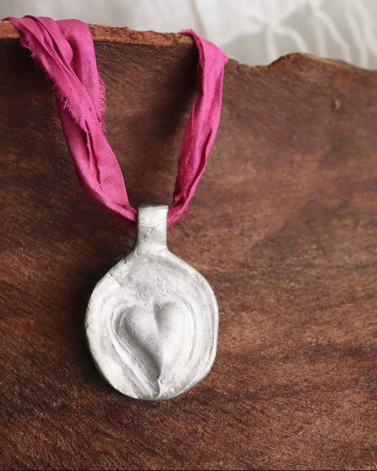 Colgante rústico de un corazón en plata. Hecho artesanalmente en España por Sandra Bellew.
