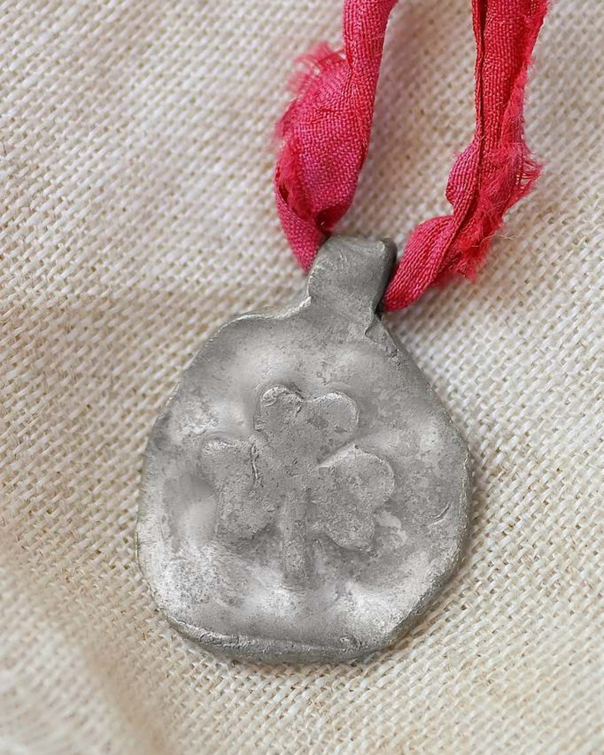 Colgante rústico de un trébol en plata. Hecho artesanalmente por Sandra Bellew.