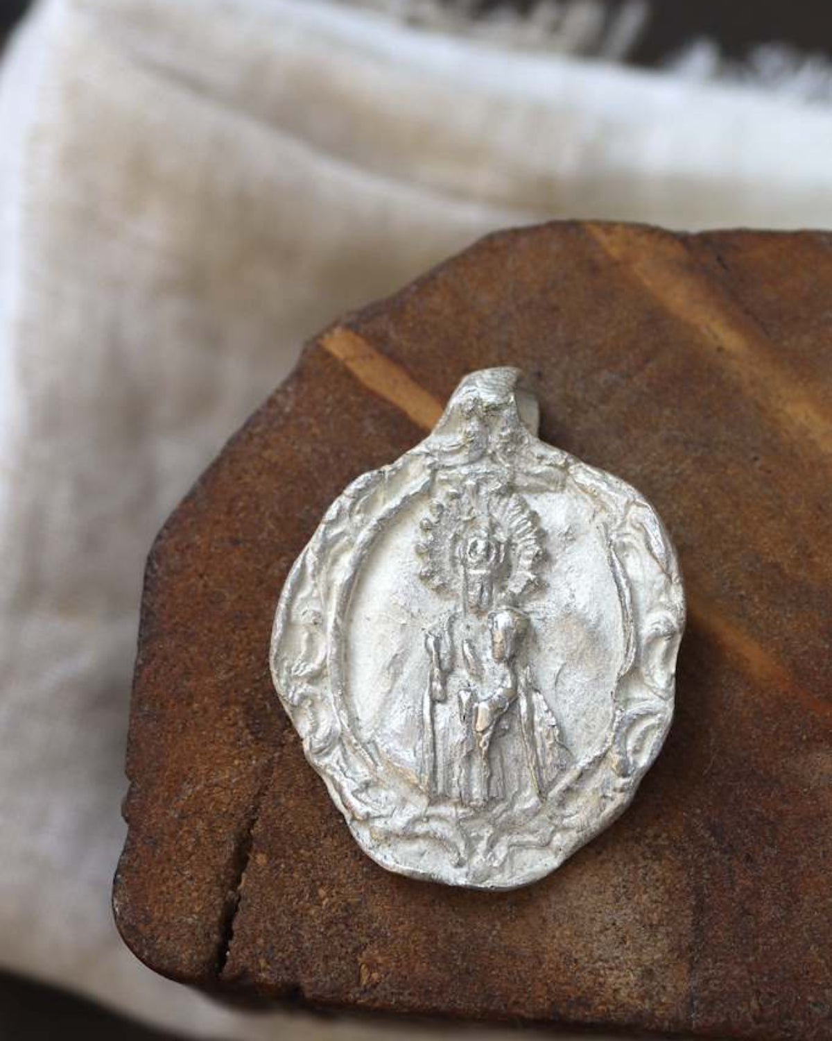 Medalla rústica de la Virgen del Puerto para carrito en plata. Hecha artesanalmente por Sandra Bellew.