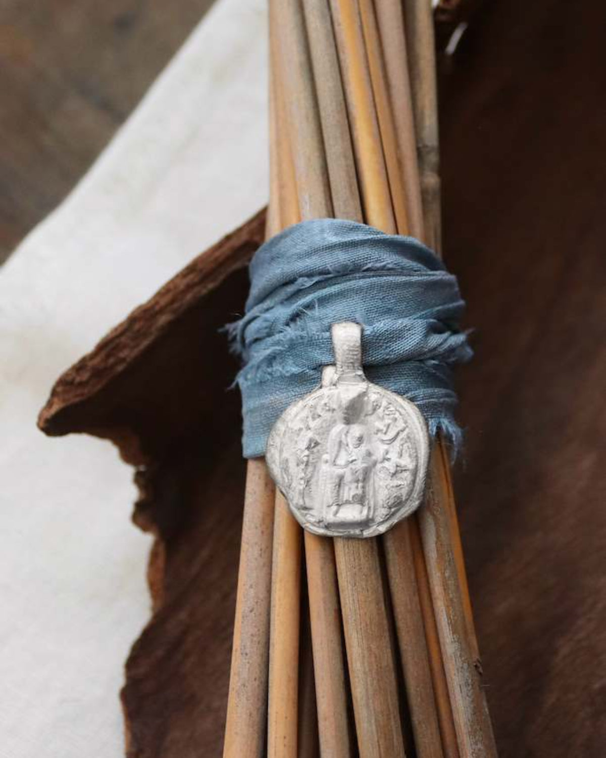 Medalla rústica de la Virgen de Nuria para ramo de novia en plata. Hecha artesanalmente en España por Sandra Bellew.